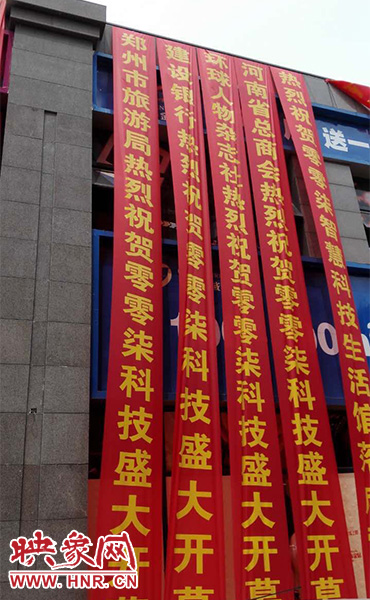 路邊一棟樓上懸掛著二三十條紅色條幅，全部是祝賀一家公司開(kāi)業(yè)的。