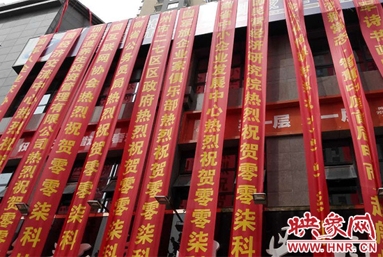 路邊一棟樓上懸掛著二三十條紅色條幅，全部是祝賀一家公司開(kāi)業(yè)的。