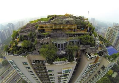 　　昨日，身穿橘黃色馬甲的工作人員在人濟(jì)山莊樓頂拆除違章建筑。新京報(bào)記者 吳江 攝