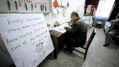 張大爺在門衛(wèi)室里工作，旁邊是紅爆網(wǎng)絡(luò)的溫馨提示牌記者
