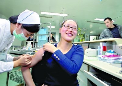 昨日，向雪敏在同濟醫(yī)院血液科病房打動員劑，丈夫陳武右在身后注視著妻子 記者傅克強