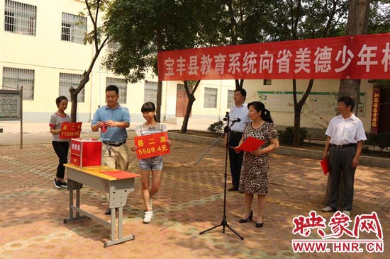 寶豐縣教育系統(tǒng)全體人員在石橋鎮(zhèn)中學為“美德少年”楊冠明同學捐款。