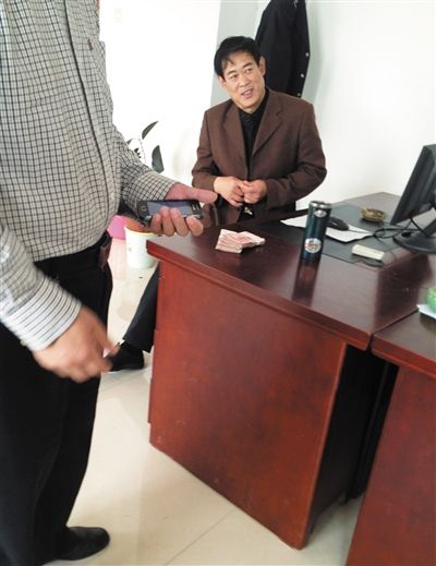 10月29日，獻(xiàn)縣國(guó)稅局稽查局辦公室內(nèi)，一名企業(yè)主交了兩萬(wàn)元現(xiàn)金在桌上。新京報(bào)記者 孟祥超 攝