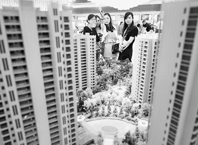 圖為近日，浙江杭州一家房產(chǎn)公司的兩位銷售人員一起向購房者介紹樓盤。新華社記者 王定昶攝