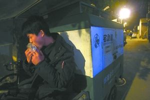 快遞哥抽空吃兩口東西。記者 李剛 攝