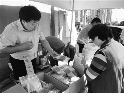 昨日，河南企業(yè)家劉春喜在京“練攤”，為顧客挑選綠豆。新京報記者 張玉學(xué) 攝