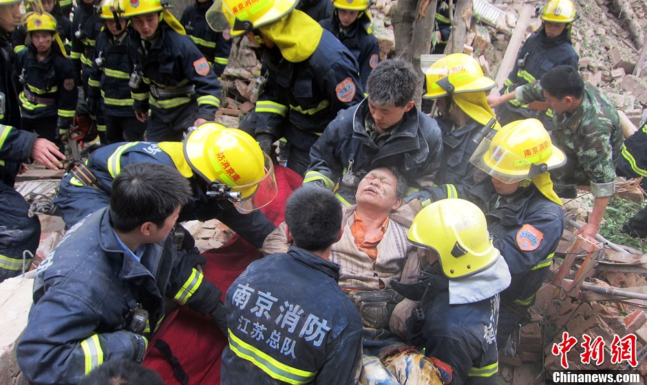 圖為南京消防隊員從廢墟中將傷者抬出。中新社發(fā) 梅亮 攝