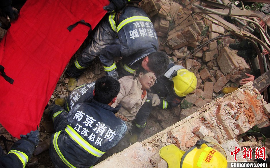 圖為南京消防隊員從廢墟中將傷者抬出。中新社發(fā) 梅亮 攝