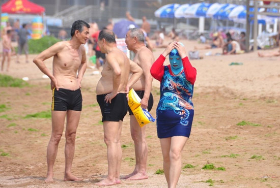 2013年7月3日，山東青島青島高溫來襲，“青島大媽”不懼滸苔，戴著“強盜面具”出現(xiàn)在海水浴場消暑降