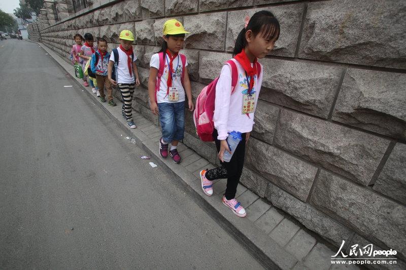 2013年09月11日，濟南運署街上，小學(xué)生走史上“最窄人行道”上學(xué)。圖片來源：CFP