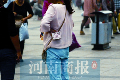 火車站廣場(chǎng)，一女子拿著寫有不同房型價(jià)位的卡片在拉客，不少市民抱怨，受過此類“騷擾”