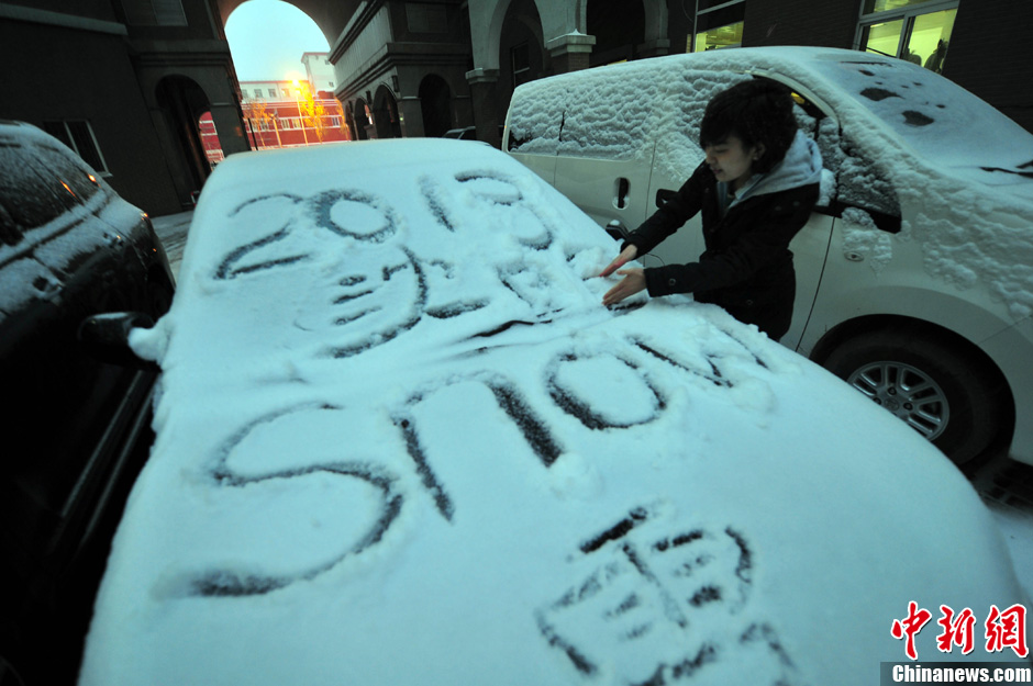 11月18日，行人在車輛的積雪上涂鴉。