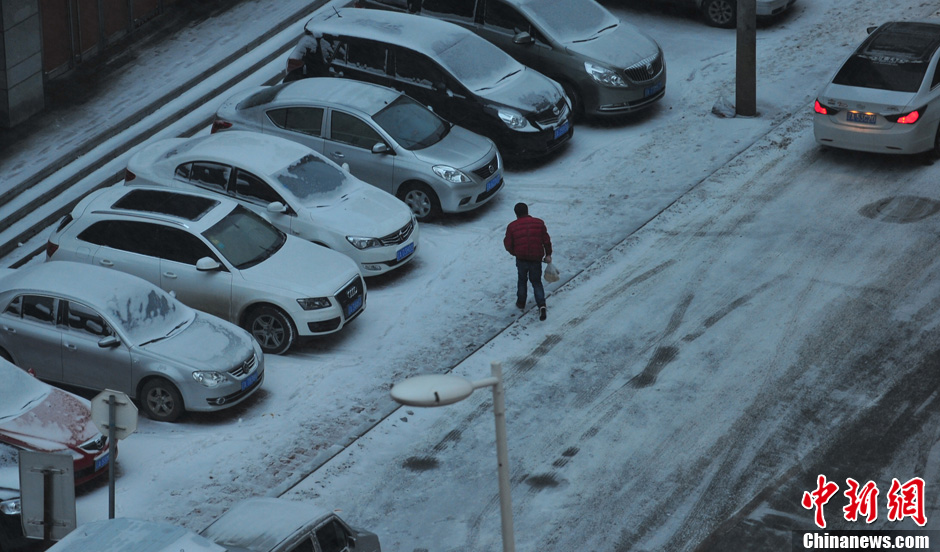 11月18日，行人在沈陽街頭的積雪中穿行。