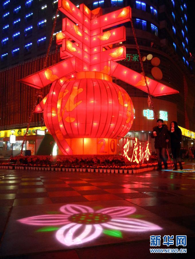 　1月30日晚，市民從蘇州市石路銀河廣場(chǎng)上大型“春”字彩燈景觀旁經(jīng)過(guò)。