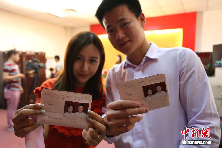 5月20日,河南鄭州,一對準(zhǔn)新人領(lǐng)完結(jié)婚證后秀自拍。