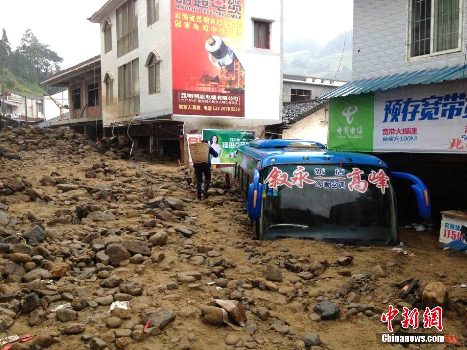 圖為山洪泥石流導沖進鄉(xiāng)鎮(zhèn)街道，導致客車被埋。