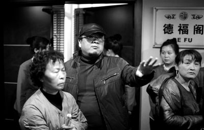 昨日，在河北香河天下第一城，相關負責人（左二）走出會議室與參加演出的老人們溝通。