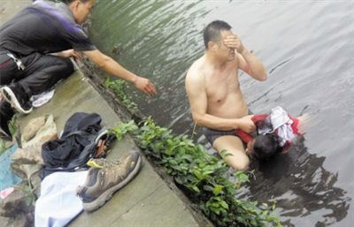 網(wǎng)友貼出民警張光聰一出河水就睜不開眼，用手抹去臉上臟水的照片。