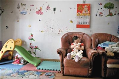 6月14日，未婚媽媽于軍的家里。女兒悅悅抱著兔子玩偶，在聽媽媽手機上的兒歌，這個4歲女孩喜歡兔子。