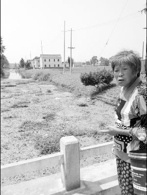 河里長(zhǎng)滿浮萍漂著垃圾，村民有時(shí)不得已用河水應(yīng)急
