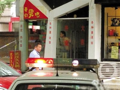 闖入面館的持刀男子與趕來的民警隔著玻璃門對峙，后店內(nèi)一名女童被其劫持。網(wǎng)友供圖