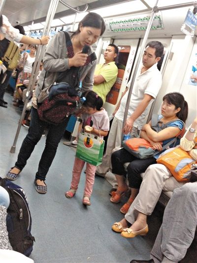 6月27日，舒馨帶一女孩在地鐵十號線行乞。她因被疑帶多個不同小孩乞討被警方搜尋。新京報記者 申志民 攝