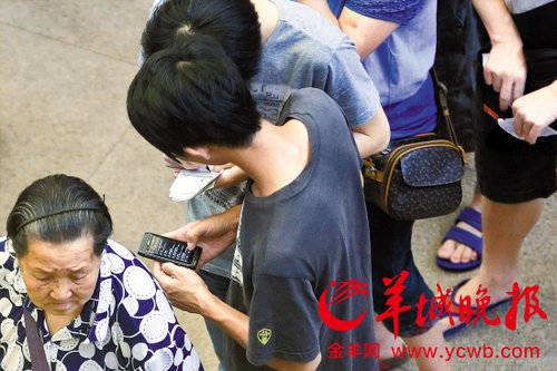 排隊的“黃?！备魇謭?zhí)一疊白紙，上面寫好了要掛號的人的信息，包括姓名、電話、要掛的科室等。穿黑白花紋衣服的老婆婆正在排隊掛號