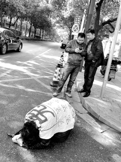 兩名接訪人員與患有癌癥的訪民段新德合影時(shí)，在拍照時(shí)查看手機(jī)。