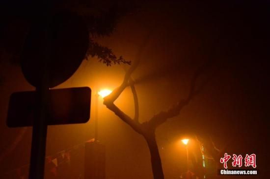 1月31日凌晨，市民行走在煙霧繚繞的南京街頭。當(dāng)天是農(nóng)歷馬年正月初一，南京有限開(kāi)禁燃放煙花爆竹正逢下霧天，空氣的不流通致使煙花爆竹燃燒后產(chǎn)生的顆粒物不能及時(shí)散開(kāi)，造成整座城市煙霧繚繞。據(jù)當(dāng)?shù)丨h(huán)保部門發(fā)布的信息顯示，空氣質(zhì)量屬重度污染。中新社發(fā) 泱波 攝