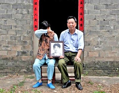 江蘇鎮(zhèn)江，老劉夫婦捧著獨(dú)生子的遺像在老家前留影南方都市報(bào)供圖L