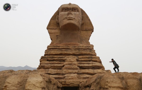 石家莊郊外，一名男子與山寨版獅身人面像合影留念。