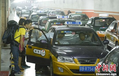 市民在北京西客站出租車候車點(diǎn)準(zhǔn)備乘車。中新社發(fā) 侯宇 攝