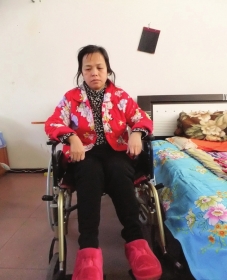 陳慶霞坐在輪椅上。她現(xiàn)在下身癱瘓，疾病纏身，生活不能自理。