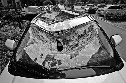 越野車車蓋以及前擋風(fēng)玻璃被砸得凹陷進(jìn)去。見(jiàn)習(xí)記者姚卡/攝