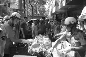 7月11日，瀏陽市北正中路，執(zhí)法人員暫扣張海的水果。這是瀏陽市城管局拍攝的執(zhí)法現(xiàn)場圖。