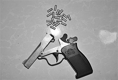 警方從搶劫嫌疑人處起獲的贓款和發(fā)令槍、子彈。警方供圖
