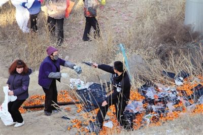 1月4日，連霍高速蘭州市榆中縣和平鎮(zhèn)段，一名警察舉著槍驅(qū)散哄搶橘子的村民。圖/CFP