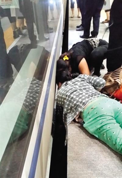 一女子趴在站臺(tái)上，救跌入列車和站臺(tái)間隙的男童。網(wǎng)友璀璨的星月夜 攝