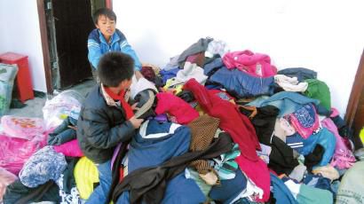 學(xué)生在幫忙整理收到的捐贈(zèng)衣服。得石中心校供圖
