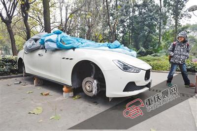 昨日，停放在重慶大學(xué)B區(qū)的一輛瑪莎拉蒂豪車被架在幾塊磚頭上，車輪不翼而飛。 重慶晨報(bào)記者 胡杰 攝