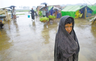 5月14日，緬甸若開邦實(shí)兌難民營，羅興亞族難民在雨中行走。熱帶風(fēng)暴“馬哈森”即將登陸緬甸，這里的難民開始乘船撤離。