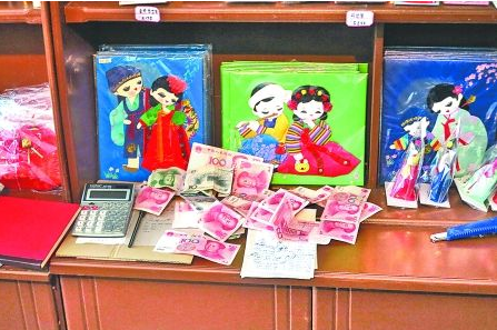 　　2012年6月21日，在朝鮮羅先特別市的一家商店里，柜臺上散落著一些人民幣。在朝鮮，人民幣比本國