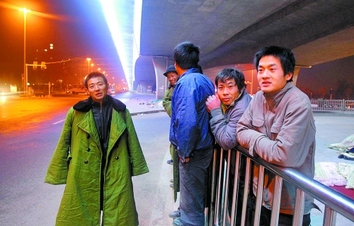 冬夜里，農民工在橋下等著干活兒。