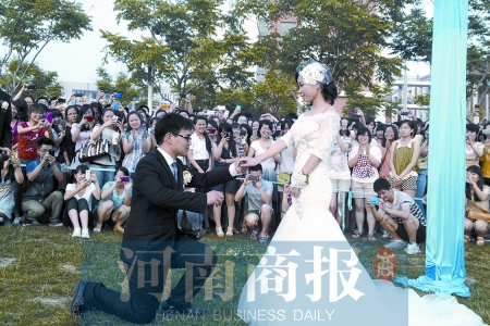 在學校操場的草坪上，兩名畢業(yè)生舉行婚禮，有同學感動地抹起眼淚