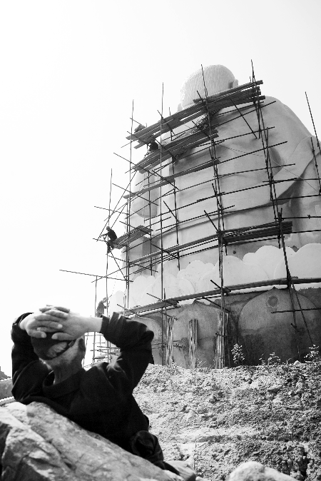 今年4月26日，工作人員將帆布蓋在“佛像”頭像上