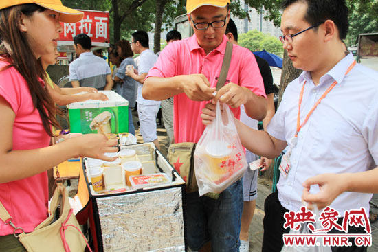 圖為徐貴雨和一名勤工助學(xué)的學(xué)生在街頭義賣快餐。