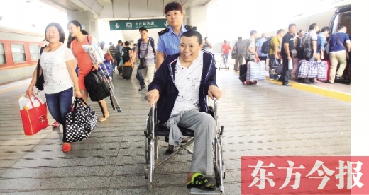 李剛手術(shù)后歸來(lái)，在車(chē)站工作人員幫助下走出鄭州火車(chē)站站臺(tái)  東方今報(bào)首席記者 張曉冬 攝