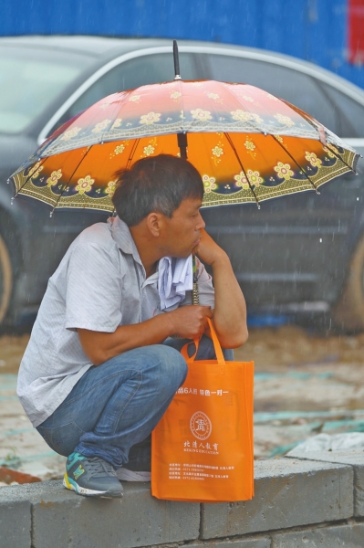 冒雨守在考點(diǎn)門外牽腸掛肚的家長