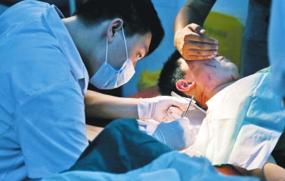 孩子身上有7道傷痕，其中兩道需要縫合，其他的均為擦傷，醫(yī)生正對(duì)他施治。