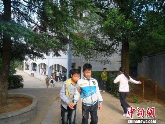 4年來，13歲的余興泉（左一）每天都攙扶著腿腳不便的同學(xué)左臣進(jìn)出教室、食堂和廁所。 李俊杰 攝